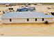 New single-story home with a light exterior, multiple windows, and a backyard in a desert setting at 25745 W Peak View Rd, Wittmann, AZ 85361