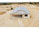 New single-story home with a light exterior, multiple windows, and a covered back patio at 25745 W Peak View Rd, Wittmann, AZ 85361