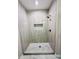 Modern walk-in shower with decorative tile, rainfall shower head, and glass surround at 25745 W Peak View Rd, Wittmann, AZ 85361