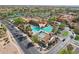 Aerial view of community pool area featuring multiple pools, sunshades, lounge seating, and palm trees at 2722 N 155Th Dr, Goodyear, AZ 85395