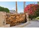 Outdoor water feature with stacked stone wall and colorful bougainvillea bush at 2722 N 155Th Dr, Goodyear, AZ 85395