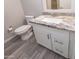 Bathroom vanity featuring granite countertops, white cabinets, stainless steel fixtures, and wood-look tile flooring at 313 E Westchester Dr, Tempe, AZ 85283
