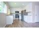 Bright kitchen features white cabinets, stainless steel appliances, stone countertops, and wood look flooring at 313 E Westchester Dr, Tempe, AZ 85283