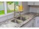 Close-up of kitchen sink featuring a stainless steel faucet, granite countertops, and a view to outside at 313 E Westchester Dr, Tempe, AZ 85283