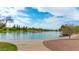 Scenic lake view with walking path, mature trees, and cloudy blue sky at 313 E Westchester Dr, Tempe, AZ 85283