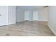 Open living room with wood-look tile flooring, neutral walls, and multiple doorways at 313 E Westchester Dr, Tempe, AZ 85283