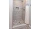 Modern tiled shower with pebble floor, built-in niche and shower curtain at 313 E Westchester Dr, Tempe, AZ 85283
