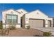 Inviting single-story home features desert landscaping and a tan-colored garage door under a clear blue sky at 3165 N 306Th Ln, Buckeye, AZ 85396