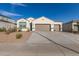 Attractive single-level home featuring a spacious driveway and a two-car garage in a desert landscape setting at 3165 N 306Th Ln, Buckeye, AZ 85396
