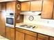 Kitchen featuring built-in oven, four-burner cooktop, and traditional wood cabinetry at 3242 W Christy Dr, Phoenix, AZ 85029