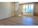 A bright living room with wood floors is highlighted by large windows with attractive drapes at 3242 W Christy Dr, Phoenix, AZ 85029
