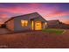 A cozy home exterior featuring a backyard patio, minimal grass, and desert landscaping under a colorful sunset at 4140 E Caitlin Dr, San Tan Valley, AZ 85140