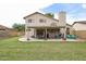 Large backyard featuring a covered patio with dining set, hanging chair, and well-maintained lawn at 4423 W Escuda Dr, Glendale, AZ 85308