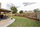 Spacious backyard with a covered patio, grassy area, and brick-lined garden beds at 4423 W Escuda Dr, Glendale, AZ 85308