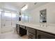 Bathroom featuring a double vanity sink, large mirror, and tiled shower at 4423 W Escuda Dr, Glendale, AZ 85308