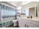 Bright bathroom with modern fixtures, updated vanity, and shower with patterned curtain at 4423 W Escuda Dr, Glendale, AZ 85308