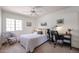 Cozy bedroom featuring neutral tones, a ceiling fan, and a workspace at 4423 W Escuda Dr, Glendale, AZ 85308