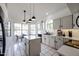 Bright kitchen featuring white cabinets, an island, tile flooring, and a breakfast nook with plenty of natural light at 4423 W Escuda Dr, Glendale, AZ 85308