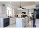 Well-lit kitchen featuring a center island, modern appliances, white cabinets and a view to the living room at 4423 W Escuda Dr, Glendale, AZ 85308