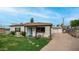 Exterior view of home showcasing the covered front porch and detached garage in a well-kept yard at 4630 N 12Th Pl, Phoenix, AZ 85014