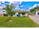 Charming single-story home with a well-manicured lawn, desert landscaping, and a bright blue front door at 4630 N 12Th Pl, Phoenix, AZ 85014