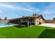 Expansive backyard with artificial turf, covered patio, and inground swimming pool at 4810 W Kelton Ln, Glendale, AZ 85306