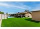 Beautiful backyard featuring artificial grass, a sparkling pool, and a covered patio at 4810 W Kelton Ln, Glendale, AZ 85306