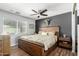 Bedroom features a rustic wood bed, ceiling fan, and modern décor for a cozy, stylish retreat at 4810 W Kelton Ln, Glendale, AZ 85306