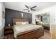 This bedroom includes a rustic wood bed, ceiling fan, sliding mirrored closet door, and modern décor at 4810 W Kelton Ln, Glendale, AZ 85306