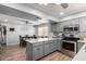 View of the kitchen featuring an eat-in bar, gray cabinetry, and stainless steel appliances at 4810 W Kelton Ln, Glendale, AZ 85306