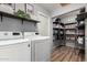 Convenient laundry room includes front load washer/dryer, shelving, and pantry space at 4810 W Kelton Ln, Glendale, AZ 85306