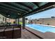 Covered patio area offering comfortable seating, a table with barstools, and views of the refreshing pool at 4810 W Kelton Ln, Glendale, AZ 85306