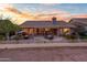 Beautiful backyard patio with outdoor seating, fire pit, and manicured landscaping at sunset at 6339 S Palo Blanco Dr, Gold Canyon, AZ 85118
