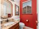 Bathroom with red accent wall features granite countertops, attractive framed mirror, and tiled floors at 6339 S Palo Blanco Dr, Gold Canyon, AZ 85118
