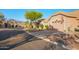 Beautiful home exterior, surrounded by mature trees, desert landscaping, and a well-kept lawn at 6339 S Palo Blanco Dr, Gold Canyon, AZ 85118