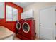 Laundry room with red appliances, white cabinetry and a door to the outside at 6339 S Palo Blanco Dr, Gold Canyon, AZ 85118