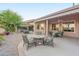 Inviting covered patio with outdoor seating, fire pit, and lush landscaping for relaxing and entertaining at 6339 S Palo Blanco Dr, Gold Canyon, AZ 85118