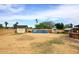 A spacious dirt backyard has a shed, a chicken coop, and many blue barrels at 6428 E Shea Blvd, Scottsdale, AZ 85254