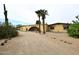 Desert home with an arched gate, gravel yard and palm trees in the front at 6428 E Shea Blvd, Scottsdale, AZ 85254