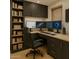 Home office with built-in shelving, dark cabinets, and a three-monitor setup at 6428 E Shea Blvd, Scottsdale, AZ 85254