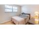 Cozy bedroom features wood floors, window with blinds, and bedside table with lamp at 6721 E Mcdowell Rd # H324, Scottsdale, AZ 85257