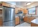 Well-lit kitchen features stainless steel appliances and wood cabinetry at 6721 E Mcdowell Rd # H324, Scottsdale, AZ 85257