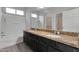 Bathroom featuring double sinks set in a granite countertop, a tub, and neutral colored walls at 7336 S 48Th Gln, Laveen, AZ 85339