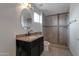 Bathroom features a tiled shower, vanity with granite countertops, and an oval mirror at 7336 S 48Th Gln, Laveen, AZ 85339