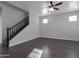 Open living room boasts sleek flooring, a ceiling fan, and staircase access to the upper level at 7336 S 48Th Gln, Laveen, AZ 85339