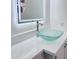 Modern bathroom vanity featuring a vessel sink, waterfall faucet, and LED backlit mirror against white walls at 7420 N 58Th Ave, Glendale, AZ 85301