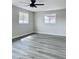 Large bedroom featuring wood-look floors, two windows, and ceiling fan at 7420 N 58Th Ave, Glendale, AZ 85301