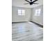 Bedroom featuring wood-look floors, two windows, and ceiling fan at 7420 N 58Th Ave, Glendale, AZ 85301