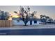Classic single-story residence featuring a tidy front yard, mature trees, and a freshly painted white facade at 7420 N 58Th Ave, Glendale, AZ 85301