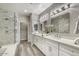 Bright bathroom with double vanity, quartz countertop, and walk-in shower with marble tiling at 815 E Rose Ln # 105, Phoenix, AZ 85014